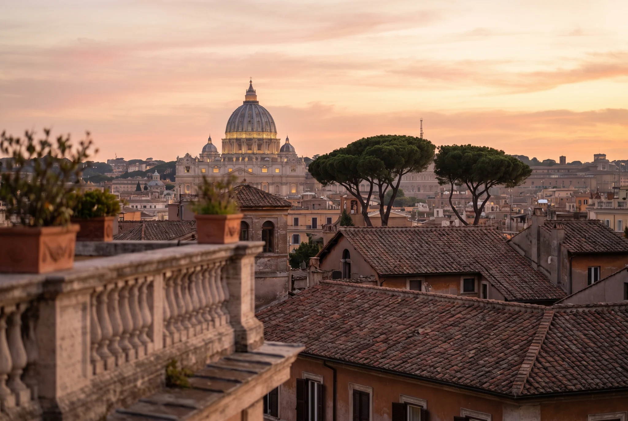 Terracotta rooftops of Rome at sunrise with the dome of St Peter's Basilica on the horizon
